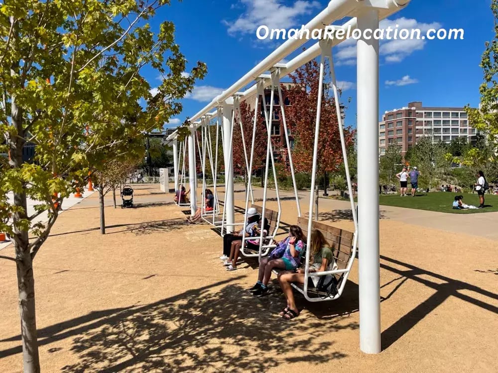 Row of bench-style swings with patrons sitting on them. 