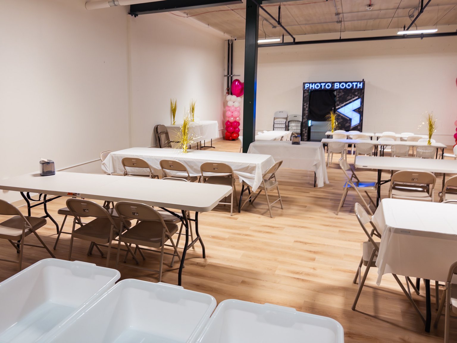 Birthday party room with tables, chairs, and photo booth.