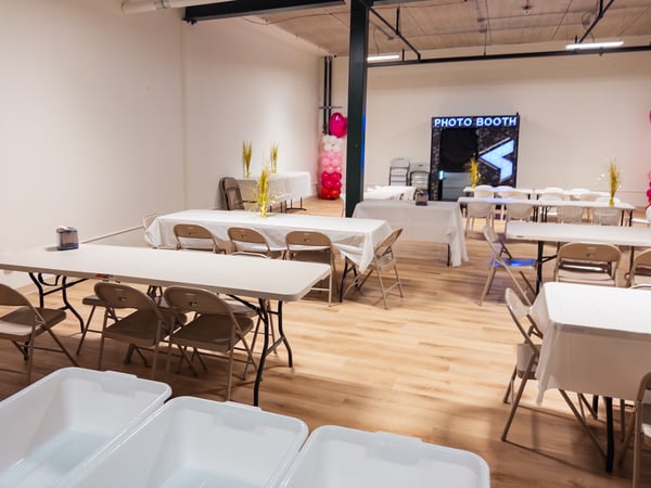 Birthday party room with tables, chairs, and photo booth.