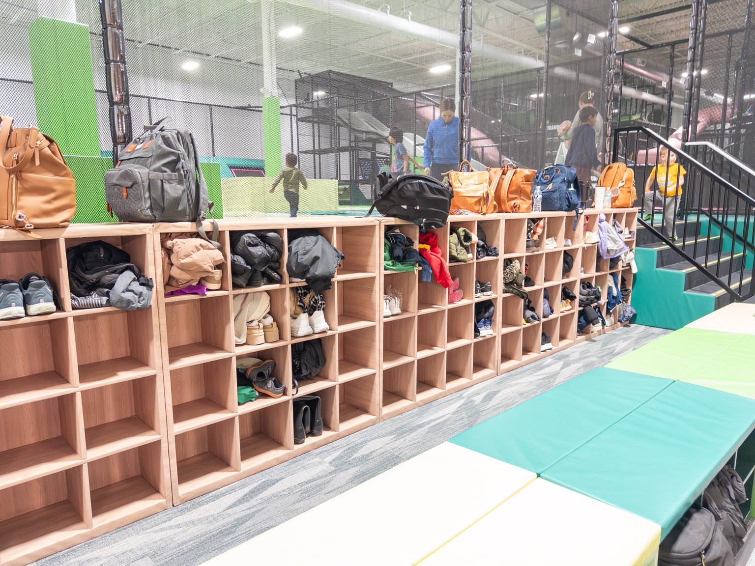 Storage area for shoes and clothes showing lots of shoes and backpacks.