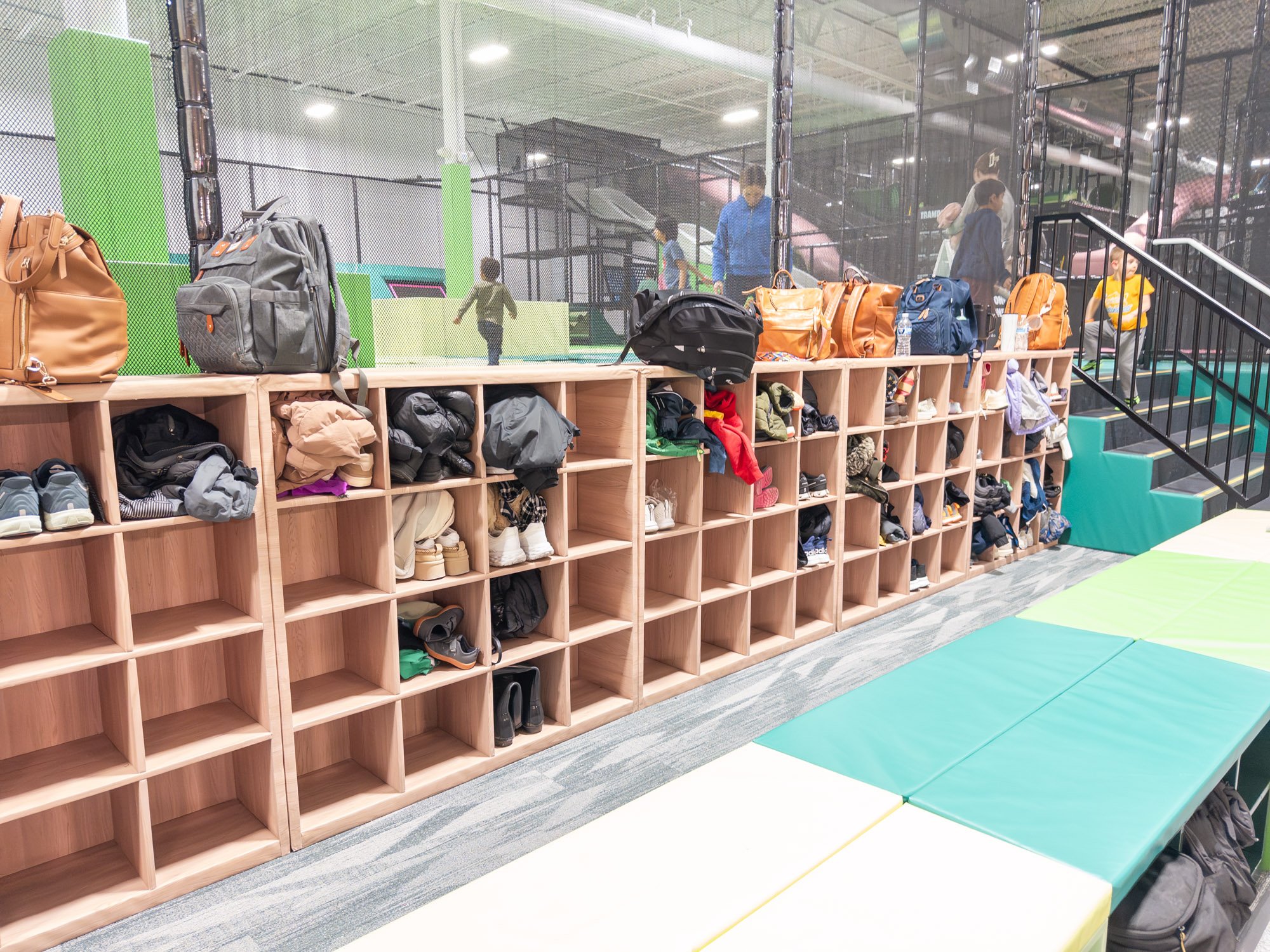 Storage area for shoes and clothes showing lots of shoes and backpacks.
