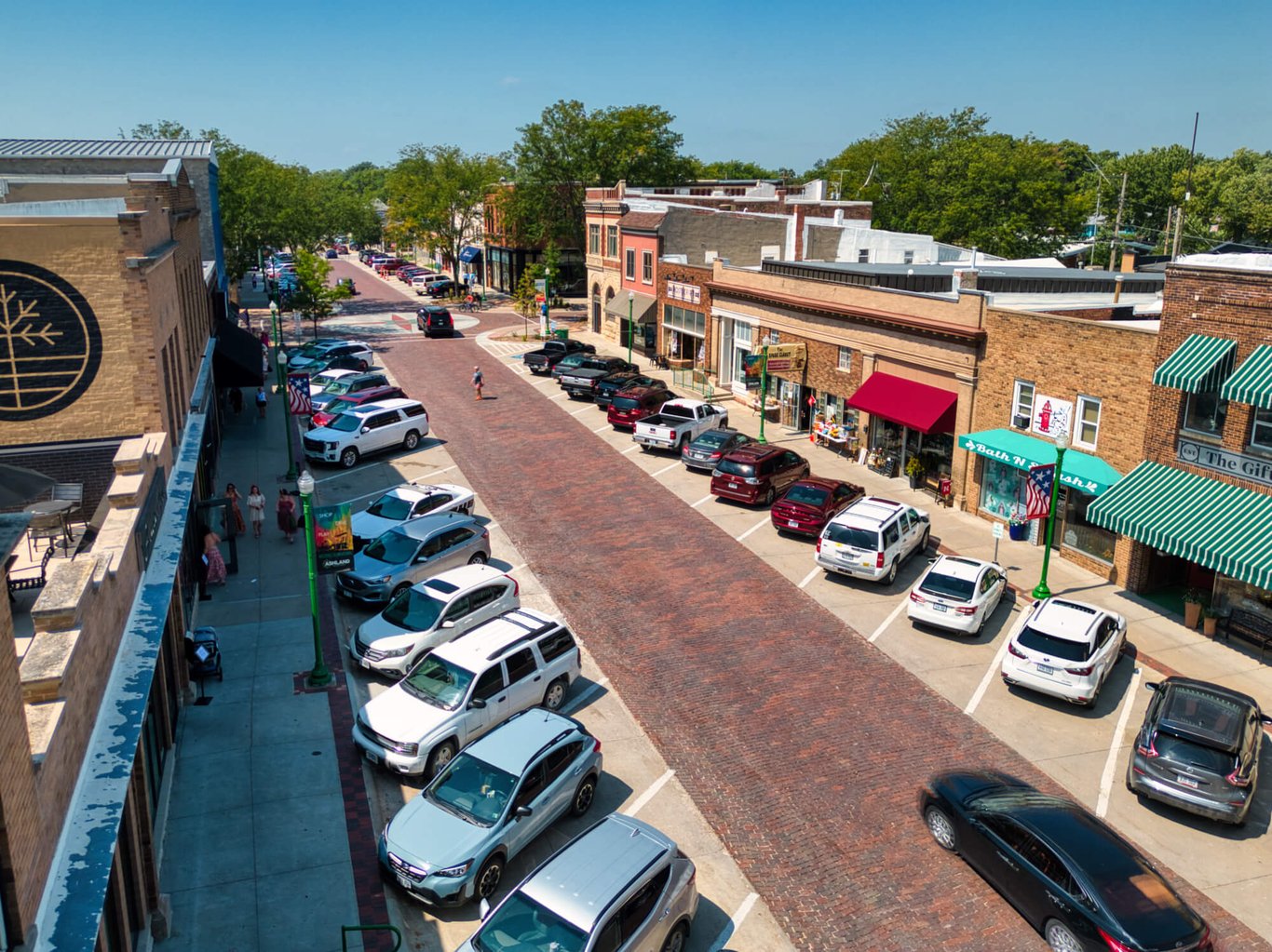 Aerial view of Downtown Ashland, Nebraska looking west down Silver Street. Cars parked along the street in front of local shops.